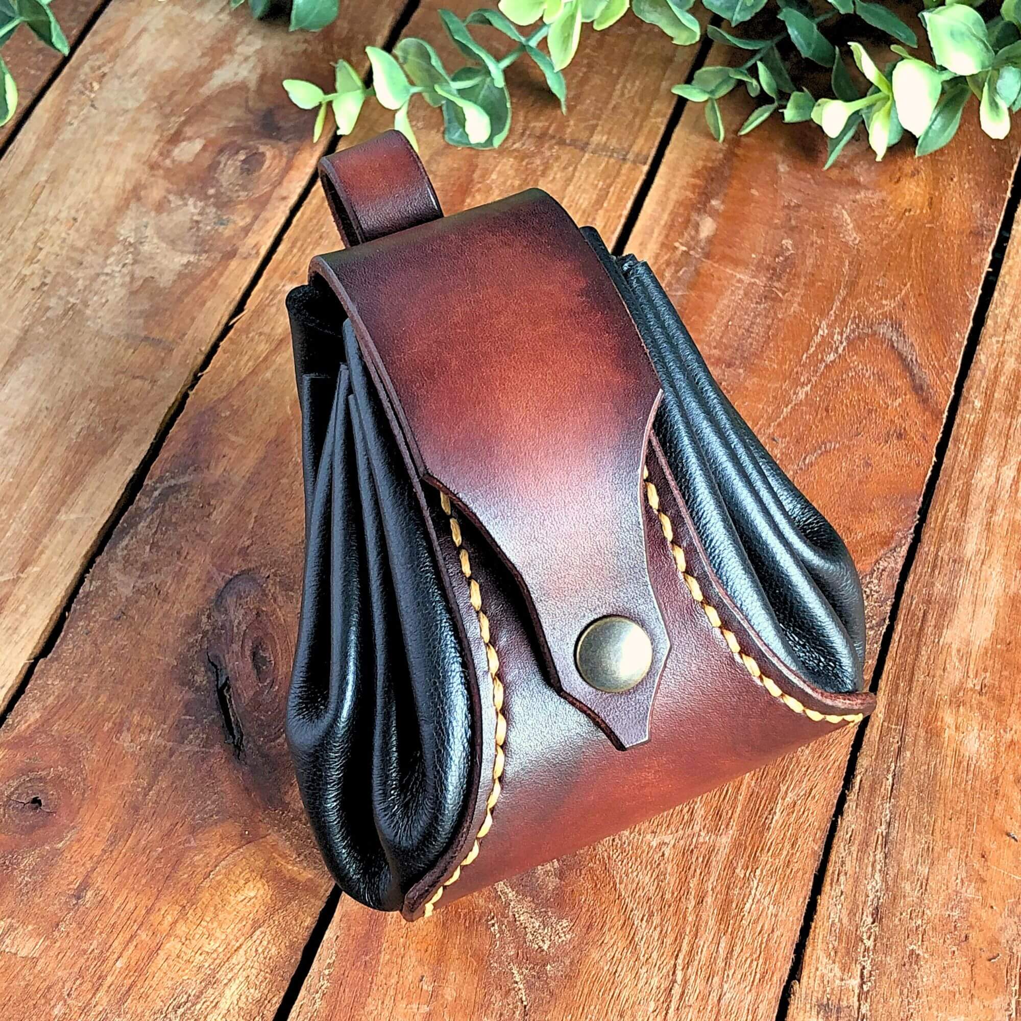 brown and black drawstring dice bag on a wooden table