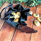black and brown drawstring bag filled with runes