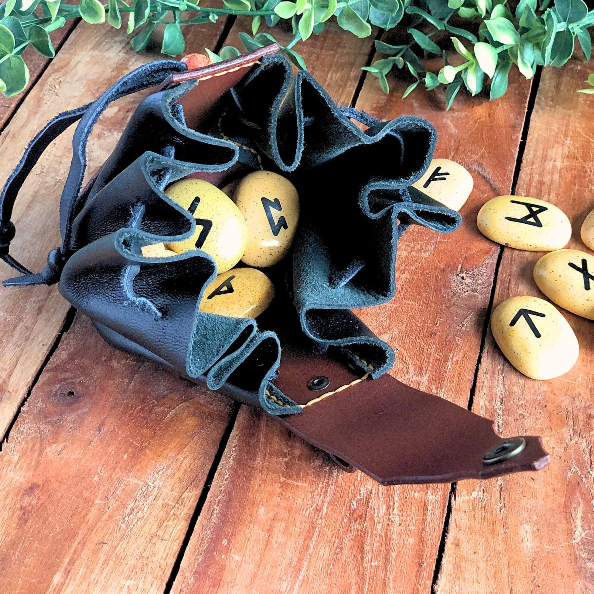 black and brown drawstring bag filled with runes