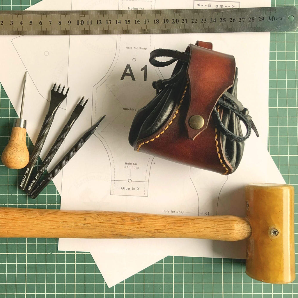 Leatherworking pattern with tools and materials on a green cutting mat.