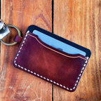 Leather cardholder with keychain on a wooden surface