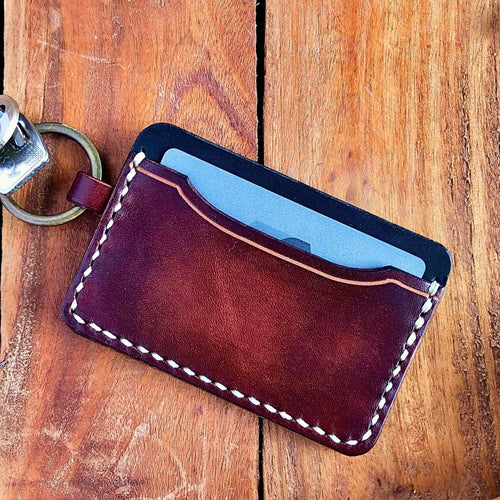 Leather cardholder with keychain on a wooden surface
