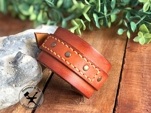 Aged-look cognac leather cuff bracelet with a stitched strap and studs