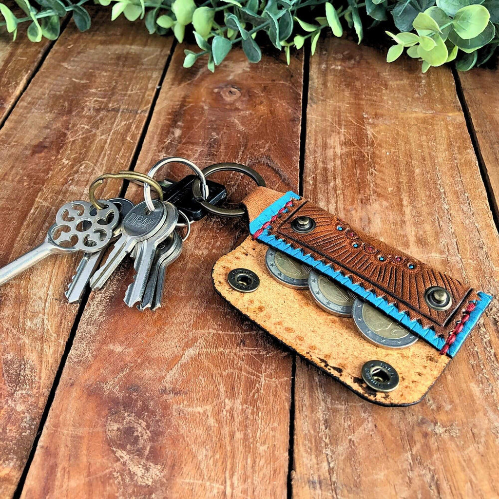 Leather Emergency Keychain Wallet filled with coins attached to keys on a wooden surface