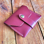 front view of a closed leather card wallet with a snap closure