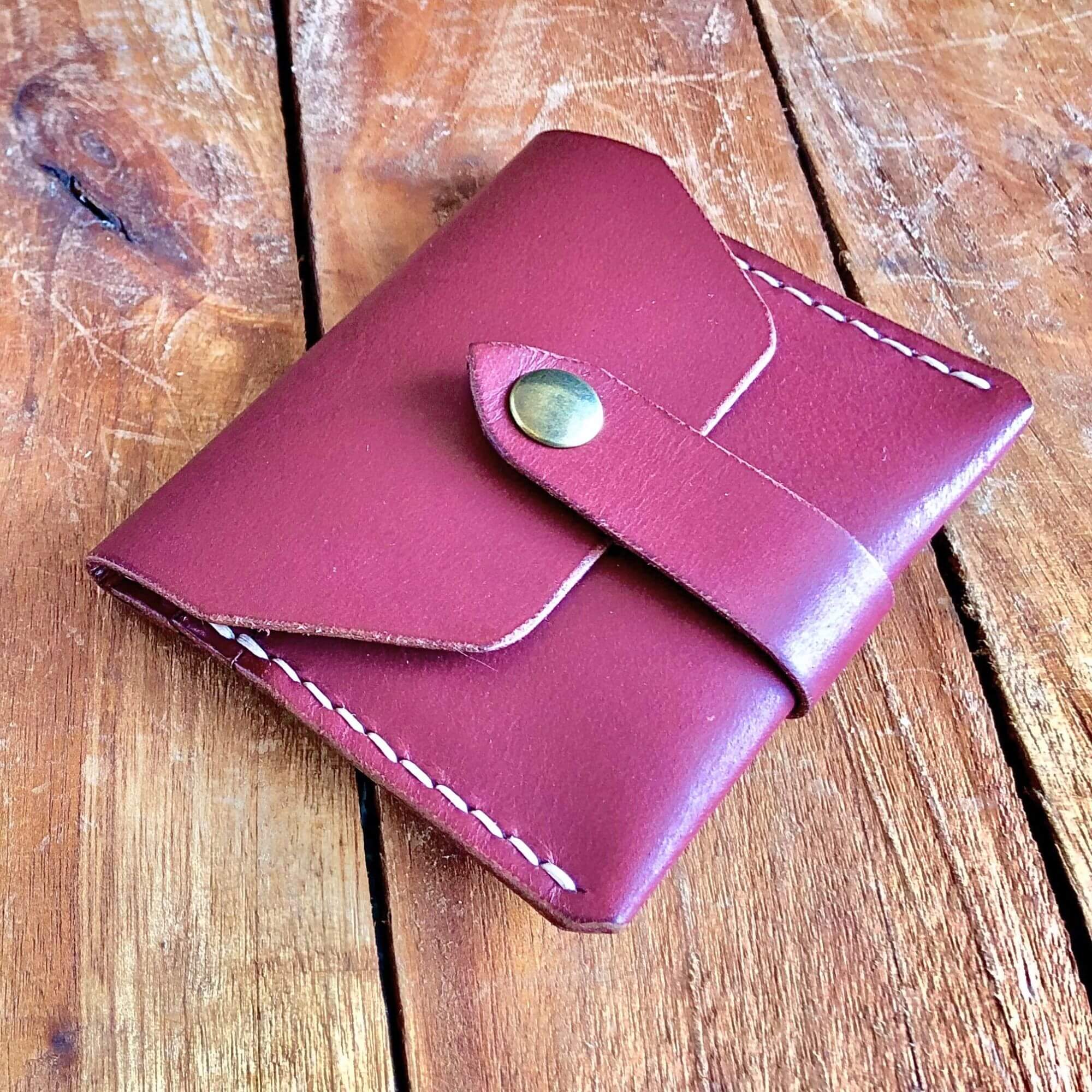 front view of a closed leather card wallet with a snap closure