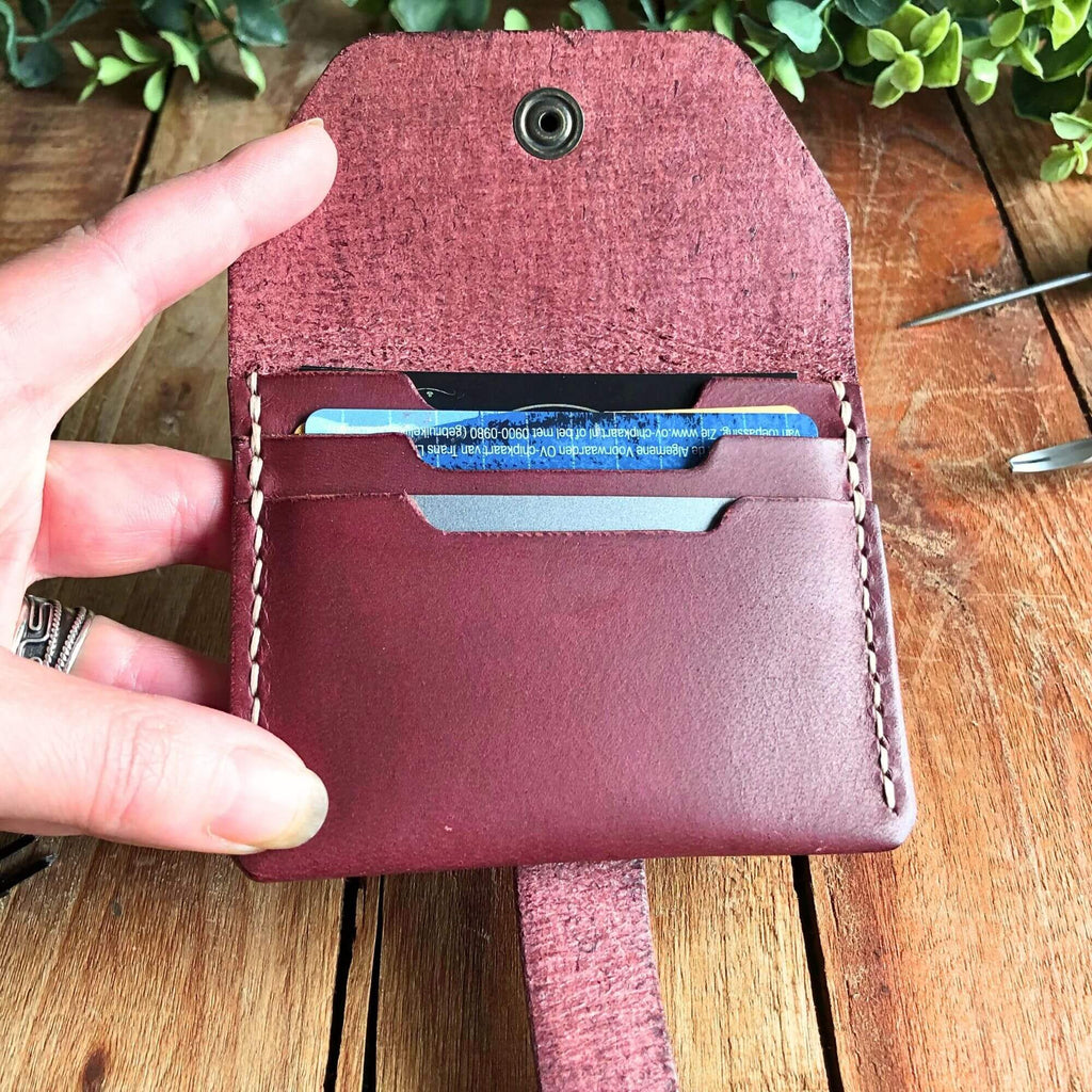 leather card wallet filled with cards held open in a hand