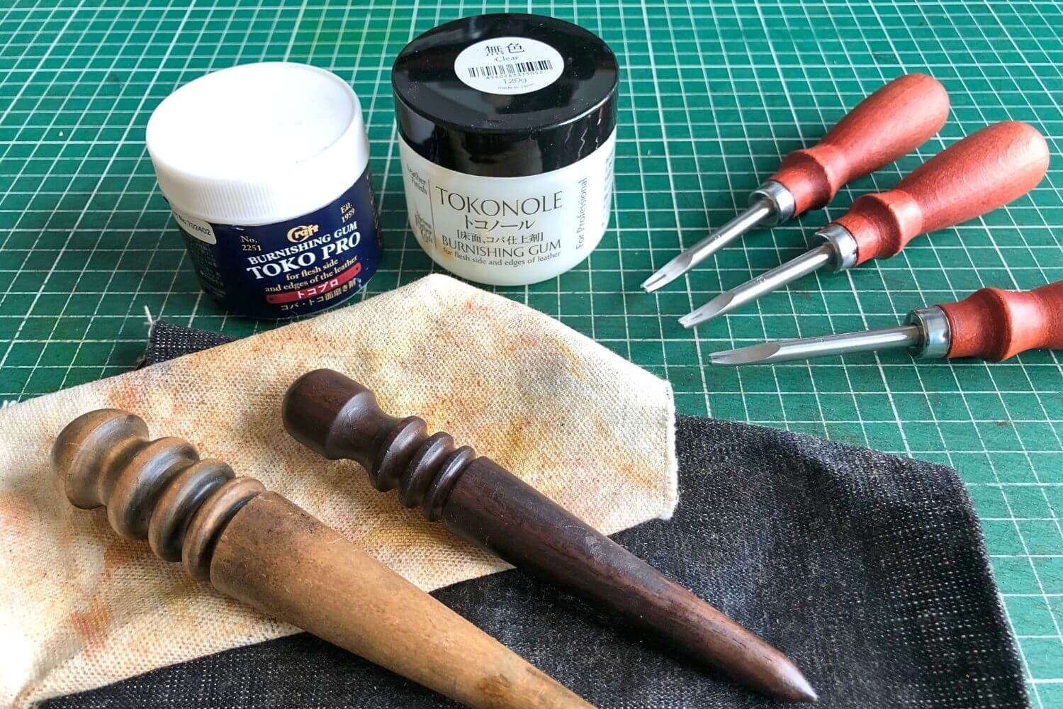 edge bevelers, burnishing compounds tokonole an toko pro plus  2 wooden slickers and canvas on a green self-healing cutting mat 