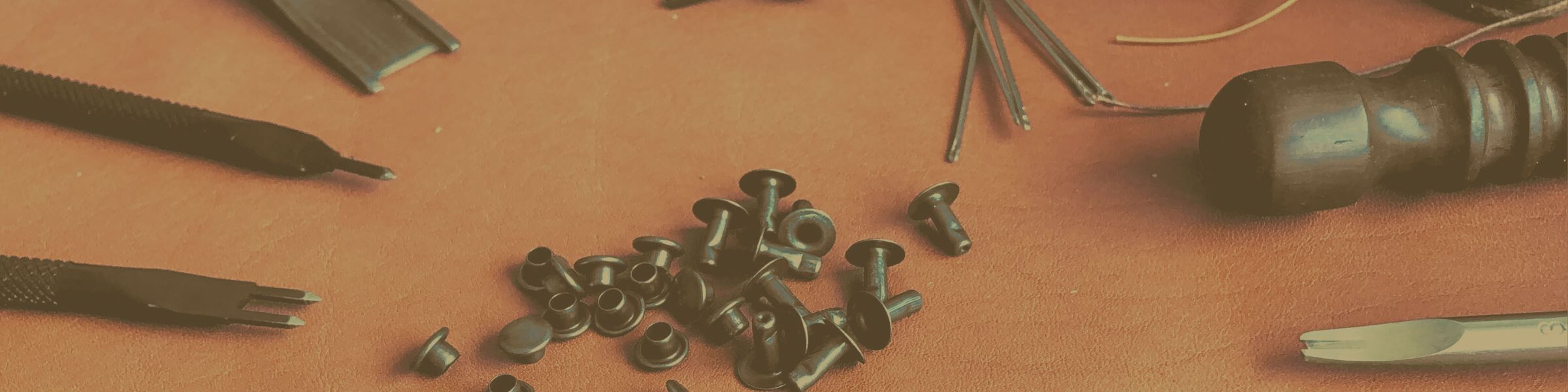 rivets and leathercraft tools on a leather background