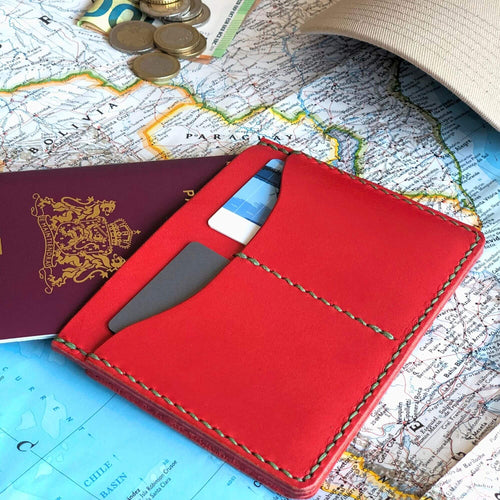 Red leather passport wallet with travel items on a world map