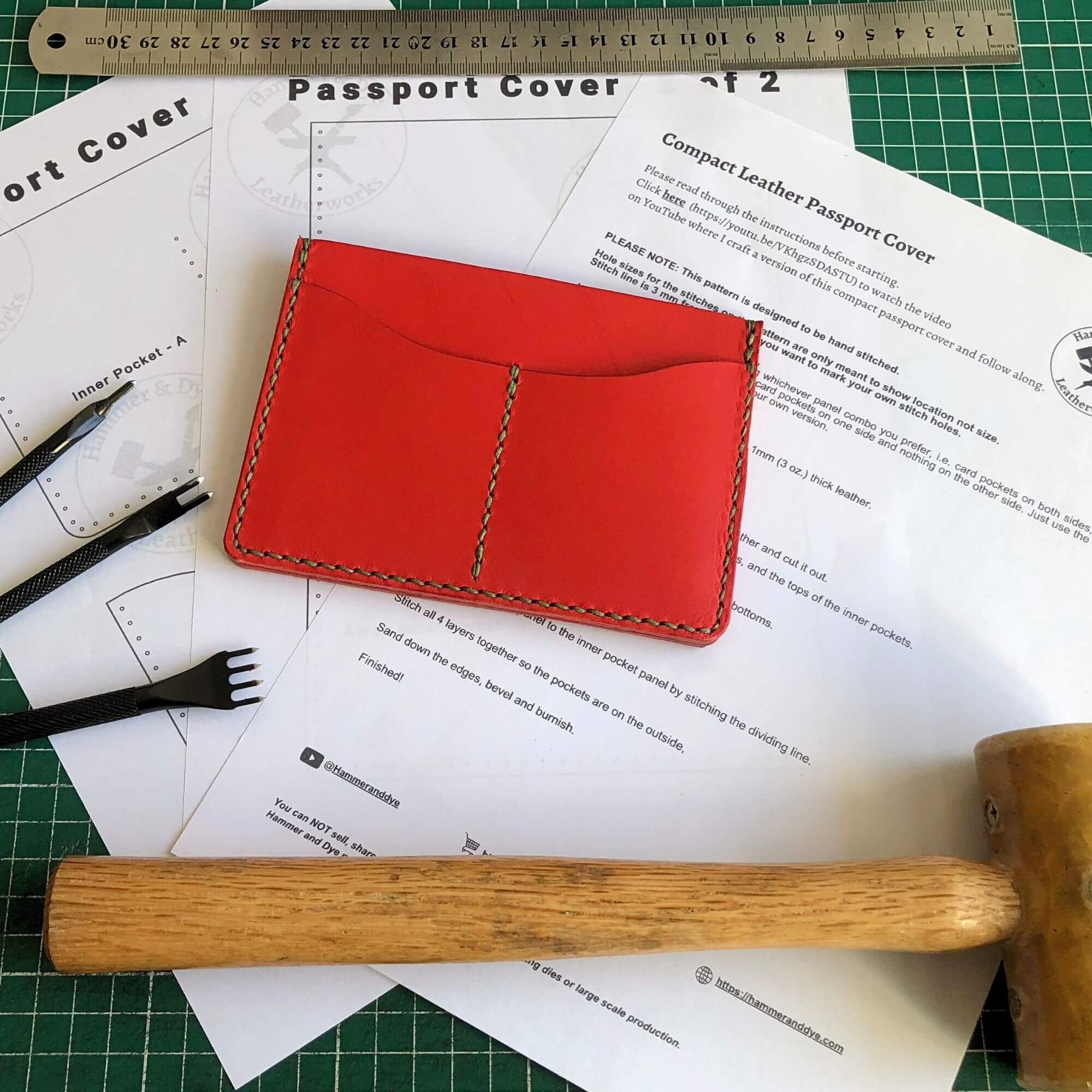 Red leather passport cover on a cutting mat with tools and  printed pattern and instructions
