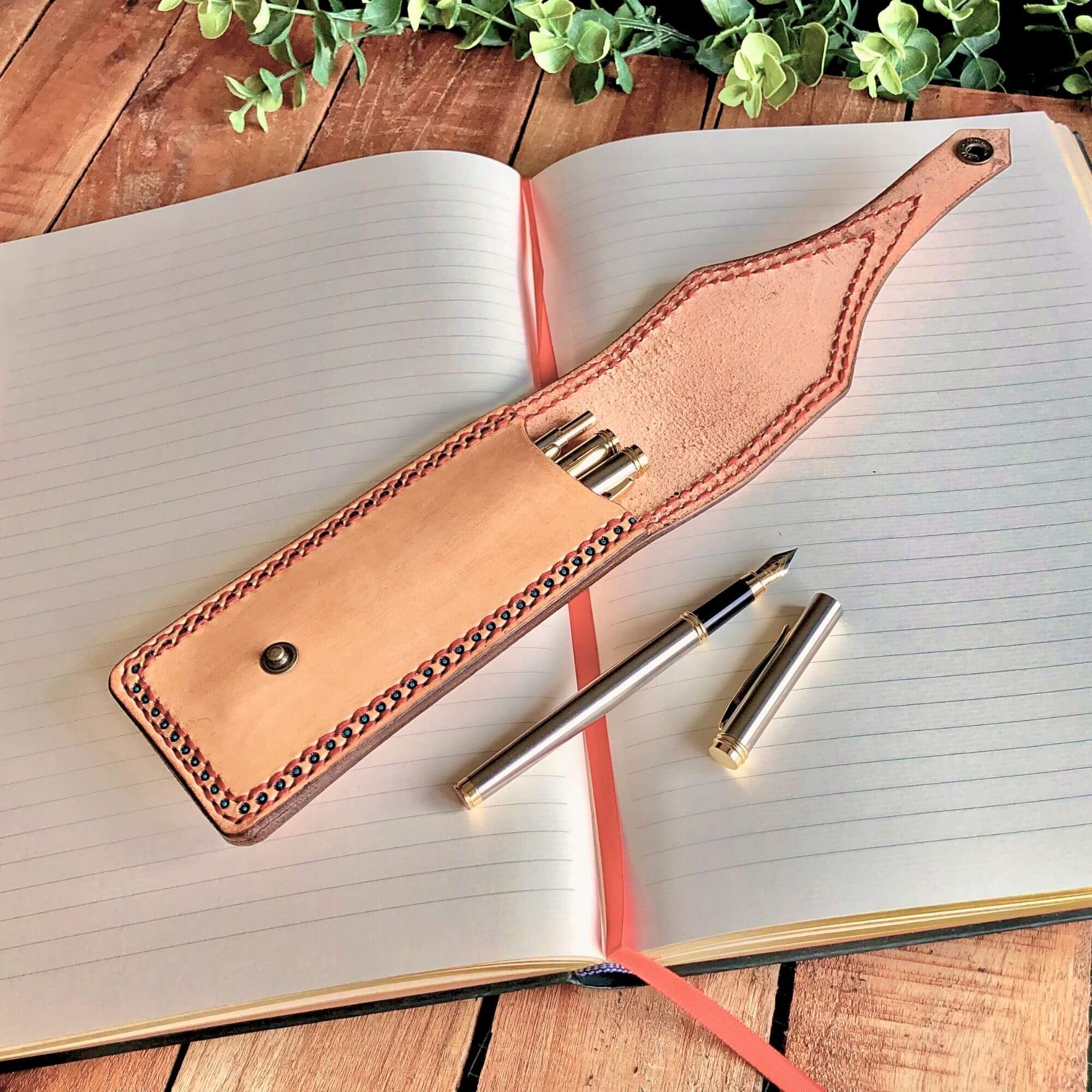 Leather pen holder with fountain pen on an open notebook