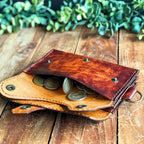 Dispatch Wallet leather PDF pattern, finished wallet laying on wooden planks with green foliage background