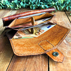 Leather wallet pattern PDF by Hammer and Dye, finished wallet with brass hardware on wooden background