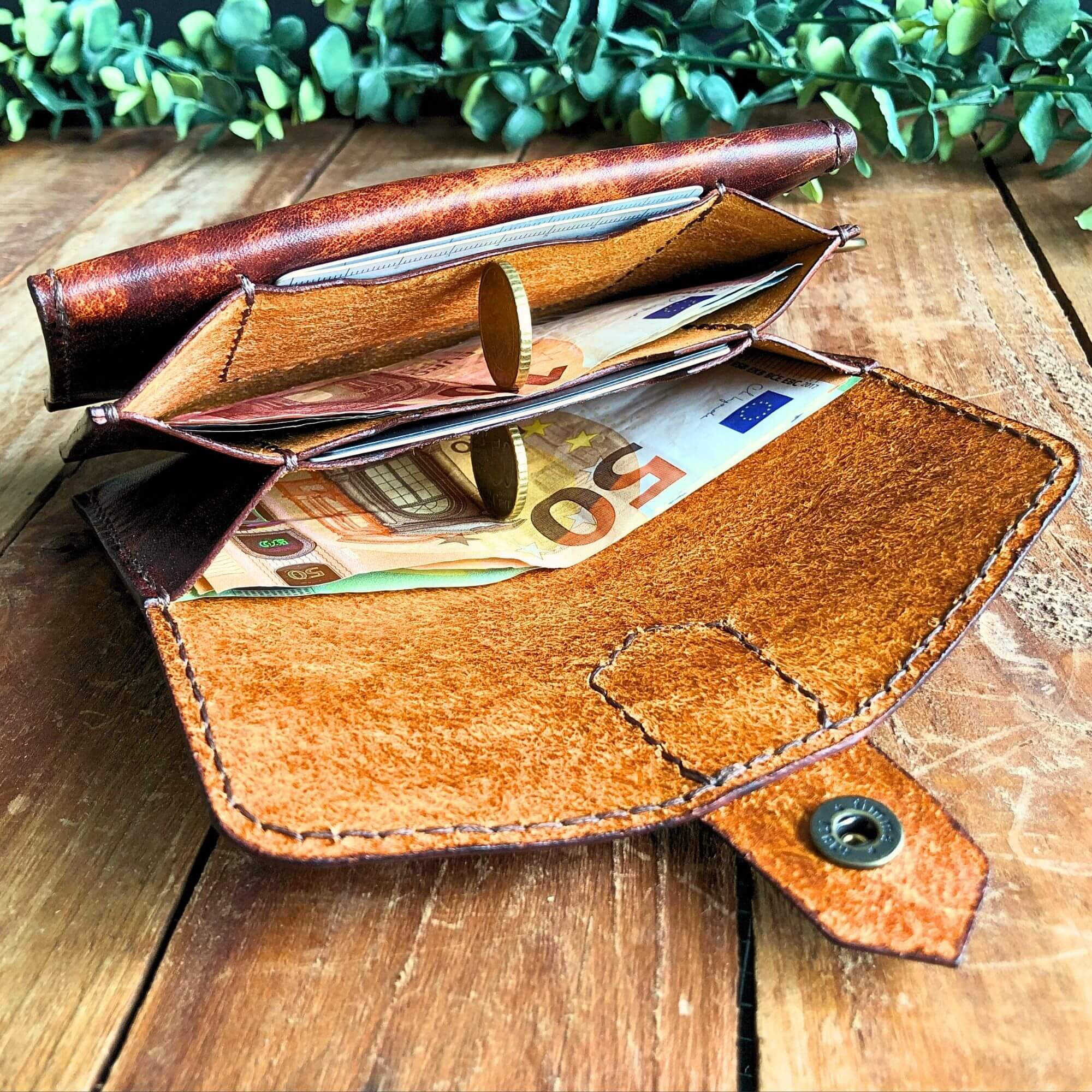 Leather wallet pattern PDF by Hammer and Dye, finished wallet with brass hardware on wooden background
